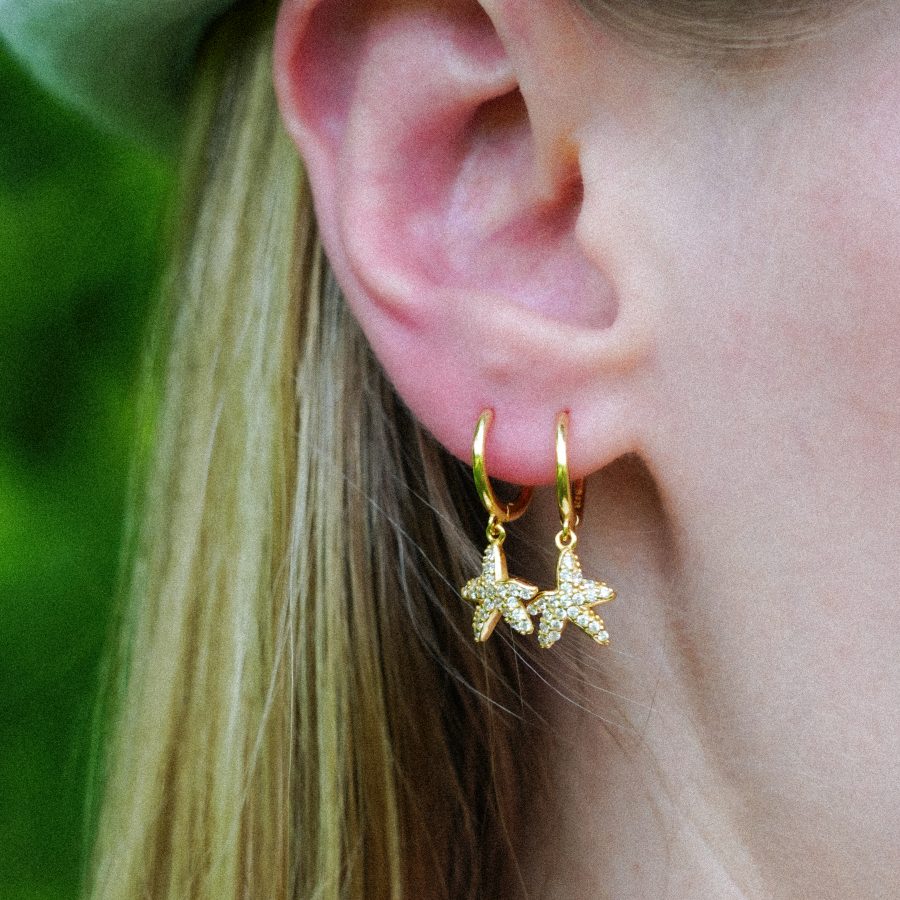 Gold Starlit Dangle Hoops drop earrings hanging on ear